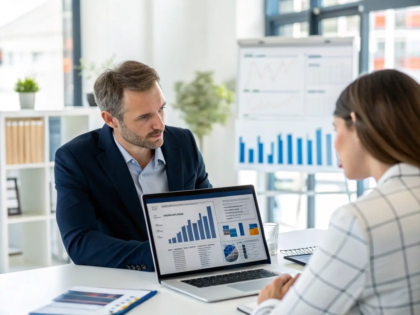 An image of a financial advisor reviewing cash flow charts on a computer screen with a small business owner, discussing strategies for improving cash flow management.